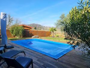 a large blue swimming pool on a wooden deck at Newlook 1 in Trélissac