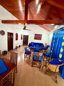 a living room with blue chairs and a table at Dara Place in Dickwella