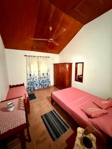 a bedroom with two beds and a ceiling fan at Dara Place in Dickwella