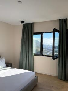 a bedroom with a bed and a large window at Pauz Hotel in Himare +174 photos