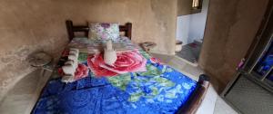 a small bedroom with a bed with a colorful quilt at Paradise Resort in Chabahinga