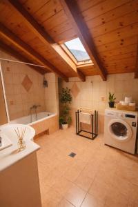 a bathroom with a washing machine and a bath tub at Konitsa Horizon Villa in Konitsa