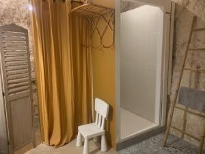 a white chair sitting in front of a shower curtain at Les Troglos de la Tufolière in Rochecorbon +49 photos