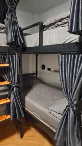 a couple of bunk beds with curtains on them at Nordic Hostel I Female Only I Dorms only in Phi Phi Islands