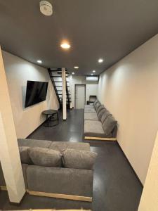 a living room with a couch and a tv at HOTTOSTAYHoNMACHI in Nagoya