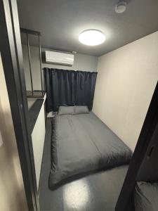 a small room with a bed and a window at HOTTOSTAYHoNMACHI in Nagoya