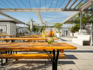a patio with wooden tables and chairs at JO&JOE Vienna in Vienna