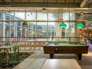 a pool table in a room with tables and chairs at JO&JOE Vienna in Vienna