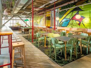 a restaurant with tables and chairs and a mural at JO&JOE Vienna in Vienna