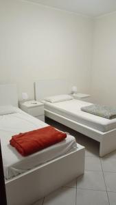 two beds in a white room with two bedsvisor at La terrazza sul mare in Messina