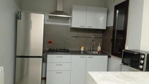 a kitchen with white cabinets and a refrigerator at La terrazza sul mare in Messina +7 photos