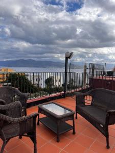 a patio with chairs and a table and a view of the water at La terrazza sul mare in Messina