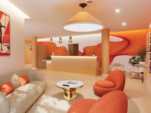 a living room with a couch and orange chairs at All Suites Hôtel Chartres Centre Gare in Chartres +2 photos