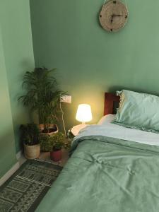 a bedroom with a bed and potted plants and a lamp at Blue Door Homes in Navi Mumbai +4 photos