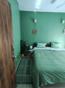 a bedroom with a bed and a blue wall at Blue Door Homes in Navi Mumbai