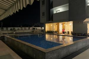a swimming pool in a building with a person standing in front of it at Nova Nest in Jaipur