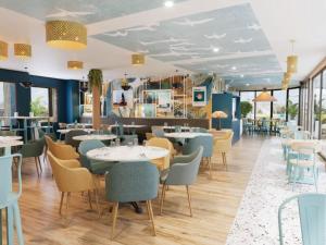 a restaurant with tables and chairs in a room at All Suites Hôtel Chartres Centre Gare in Chartres