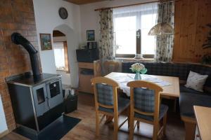 a living room with a table and a wood stove at Ferienhaus Kammerer in Haidberg