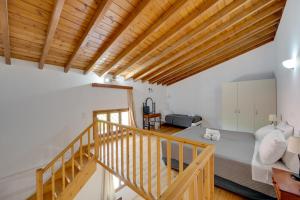 a room with a bed and a wooden ceiling at Olive Press Hotel in Mythimna