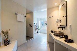 a bathroom with a sink and a mirror at Rocabella Santorini Hotel & Spa in Imerovigli +163 photos