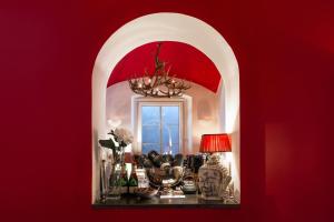 a room with a red wall with a table with a mirror at Lesar Hotel Angel - Member of Hip Hotels in Ljubljana