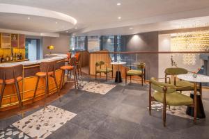 a restaurant with a bar with chairs and tables at Dorsett Hotel Canary Wharf in London +37 photos