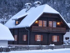 a log cabin with a snow covered roof at Ferienhaus Almenblick in Fellbach