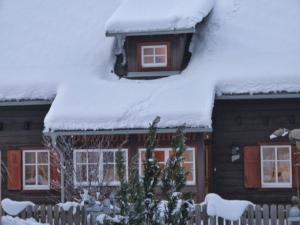 a house with snow on the roof of it at Ferienhaus Almenblick in Fellbach