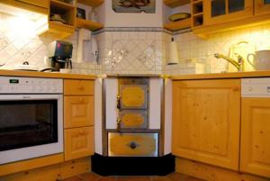 a kitchen with wooden cabinets and a white oven at Ferienhaus Almenblick in Fellbach +14 photos