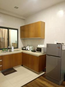 a kitchen with wooden cabinets and a stainless steel refrigerator at Bayt Rizq Homestay 3R2B in Brinchang