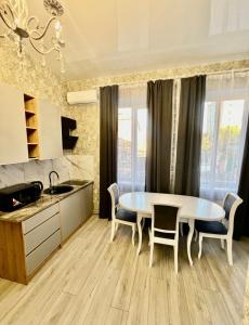 a kitchen with a table and chairs in a room at Апартаменти Карабінерная 14 in Kropyvnytskyi
