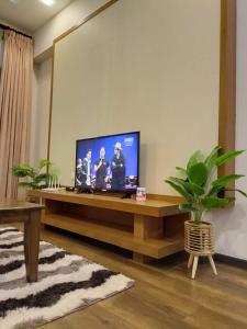 a living room with a television on a table at Bayt Rizq Homestay 3R2B in Brinchang +5 photos