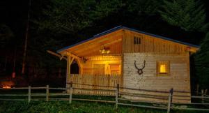a small log cabin at night with a fence at Annenhütte in Reichenfels