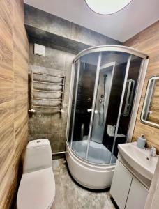 a bathroom with a shower and a toilet and a sink at Апартаменти Карабінерная 14 in Kropyvnytskyi