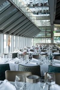 a restaurant with white tables and chairs with wine glasses at Schnellenburg in Düsseldorf