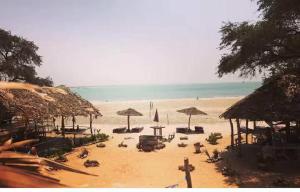 a beach with chairs and umbrellas and the ocean at Happy Corner Beach Garden in How Ba