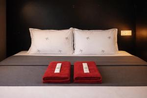 a bed with two red towels and two pillows at Start House 5 mins walk Airport in Ho Chi Minh City