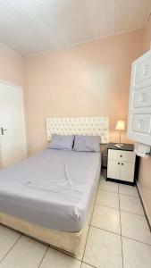 a bedroom with a bed and a night stand with a lamp at Chácara das Mangueiras in Aracaju +6 photos