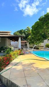 a resort with a swimming pool and flowers at Chácara das Mangueiras in Aracaju