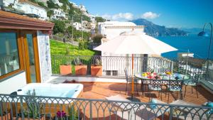a balcony with a table and an umbrella at Amalfi House Marlidia in Conca dei Marini