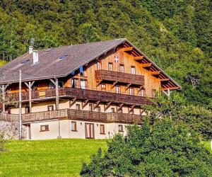 a large wooden house with a balcony on a hill at Ecrin des anges in Vacheresse