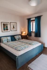 a bedroom with a blue bed with blue curtains at Kultur Weingut Kästenburg in Ratsch an der Weinstraße