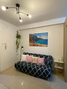 a living room with a couch and a painting on the wall at Haven's Suites a place like home in Manila +27 photos