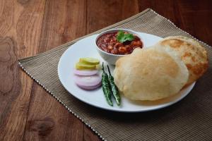 a plate of food with a burrito and a bowl of chili at Comfy GK Residency in New Delhi