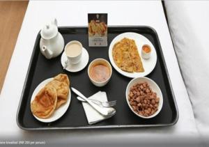 a tray of food with breakfast foods on it at Comfy GK Residency in New Delhi +16 photos