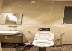 a bathroom with a toilet and a sink at Comfy GK Residency in New Delhi