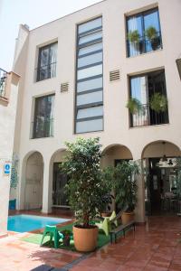 a building with a pool in front of it at Ten To Go Hostel in Barcelona