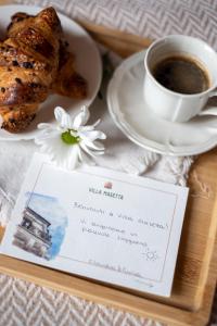 a menu on a tray with a cup of coffee and a pastry at Villa Masetta - Luxury Suites in Mondello