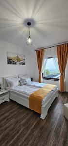 a bedroom with a large bed and a window at Arizona Ranch in Râșca +49 photos