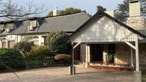 a house with a metal roof on a brick driveway at Hotel Prater in Villa General Belgrano